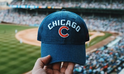 人拿着蓝色的芝加哥小熊队的帽子
